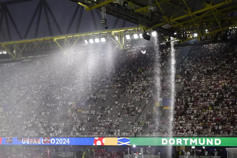 Hujan deras mengguyur lapangan disertai petir di Stadion Dortmund, saat pertandingan Jerman melawan Denmark pada 16 besar Euro 2024.
